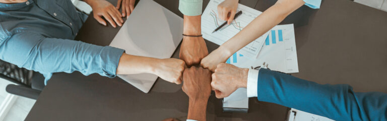top view of group multi ethnic coworkers stacked hands together as concept of corporate unity
