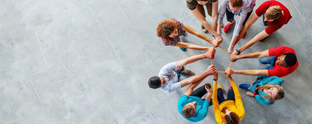 equipo de trabajo formando una figura en equipo desde arriba, simbolizando colaboración y alto desempeño