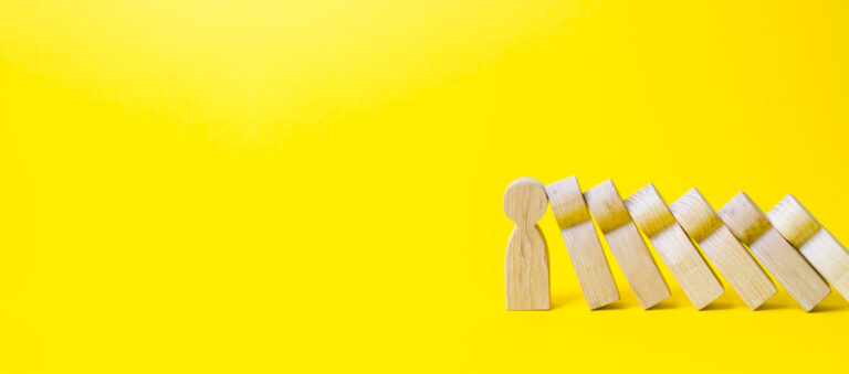 the figure of a person stops the fall of a set of figures like dominoes. business training, self improvement, stress resistance. colaps dominoes. strong leader and reliable support and loyal. banner